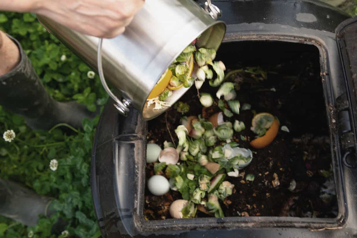 Throwing food waste into a composter