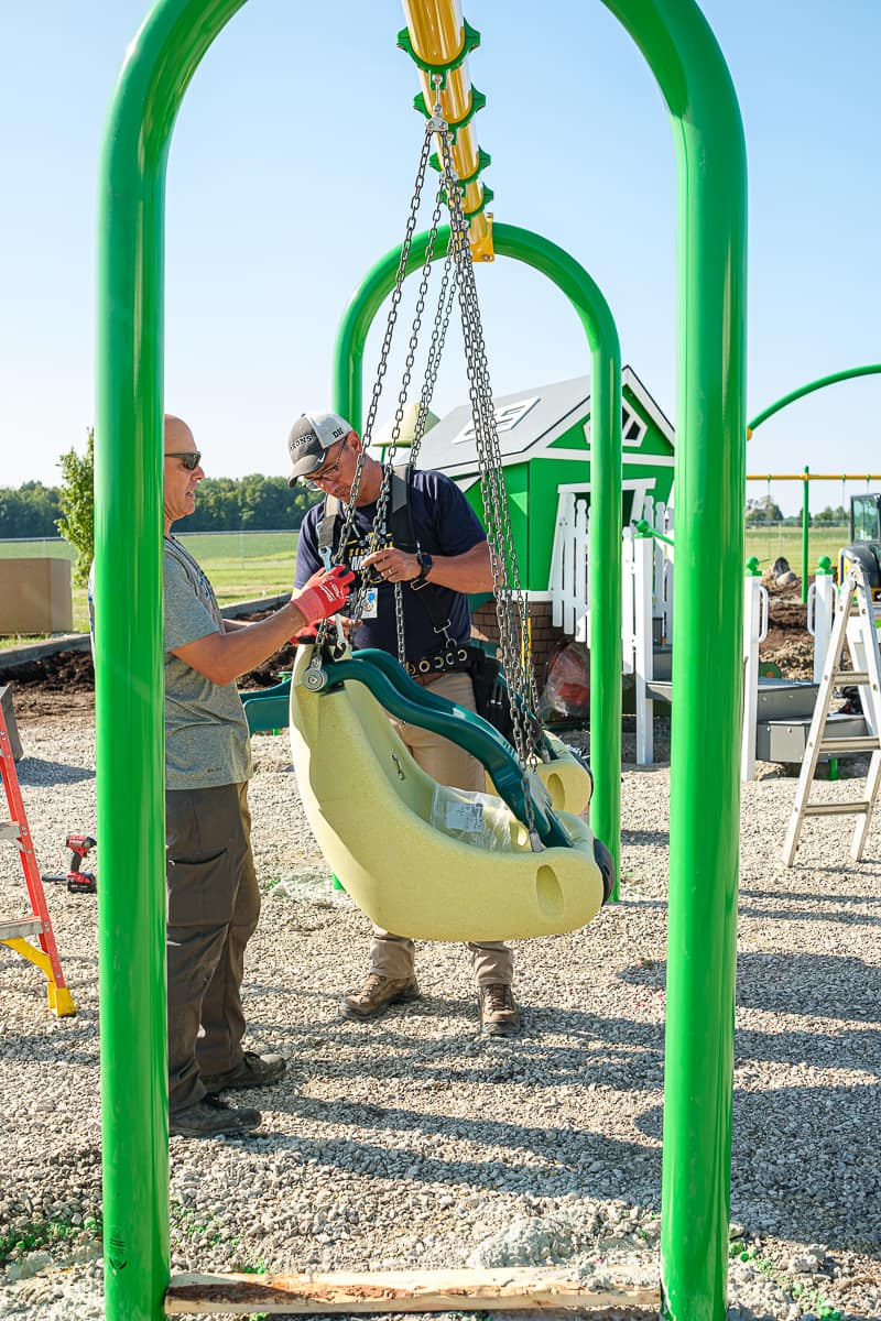 A swing set being built on a playground