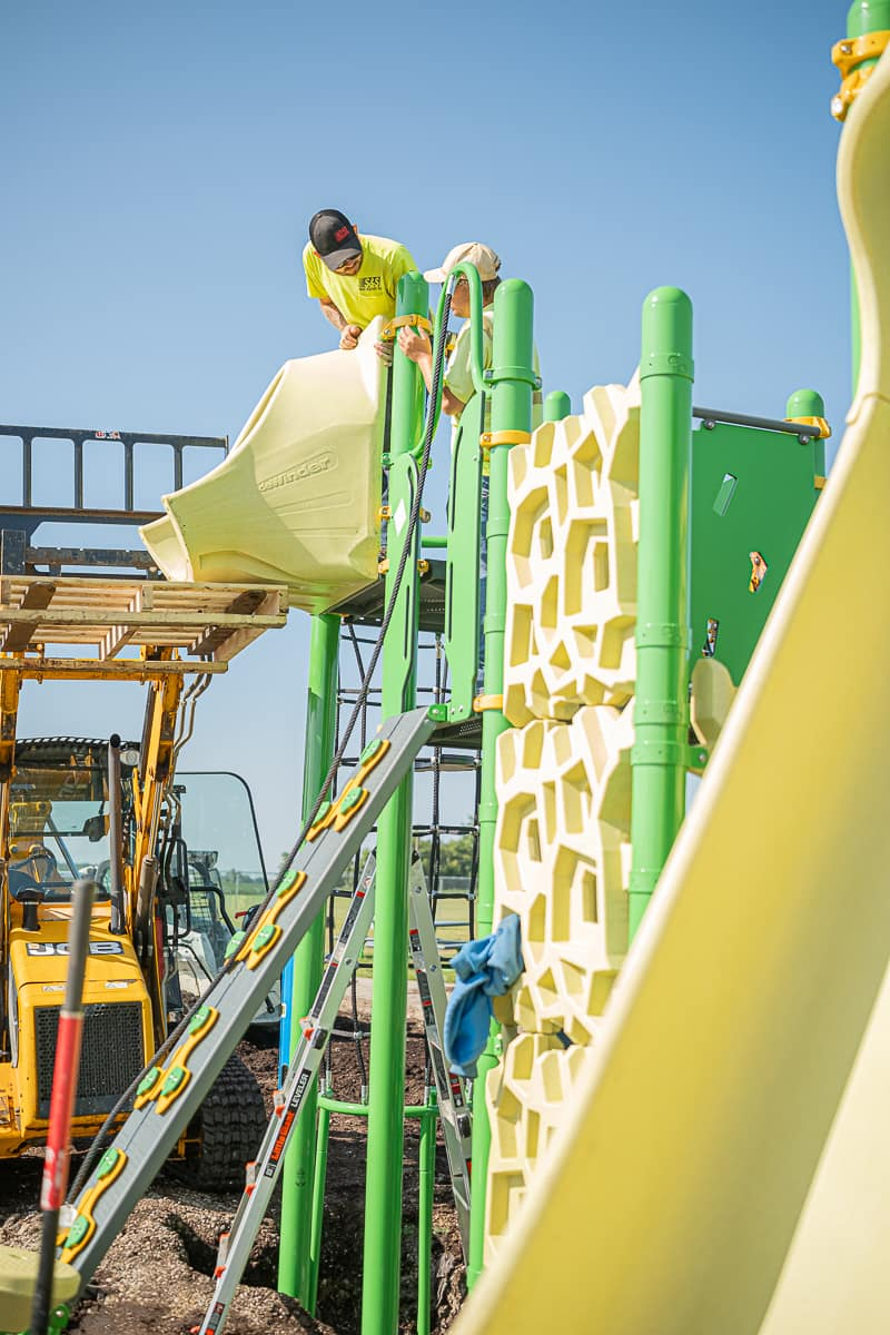 A playground being built with a slide in the front