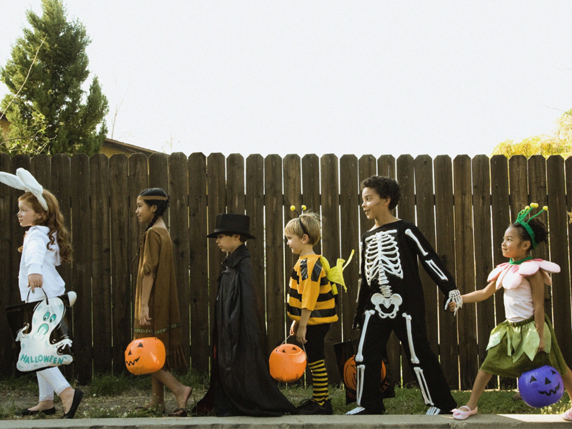 Kids in Halloween Costumes Holding Hands in Line