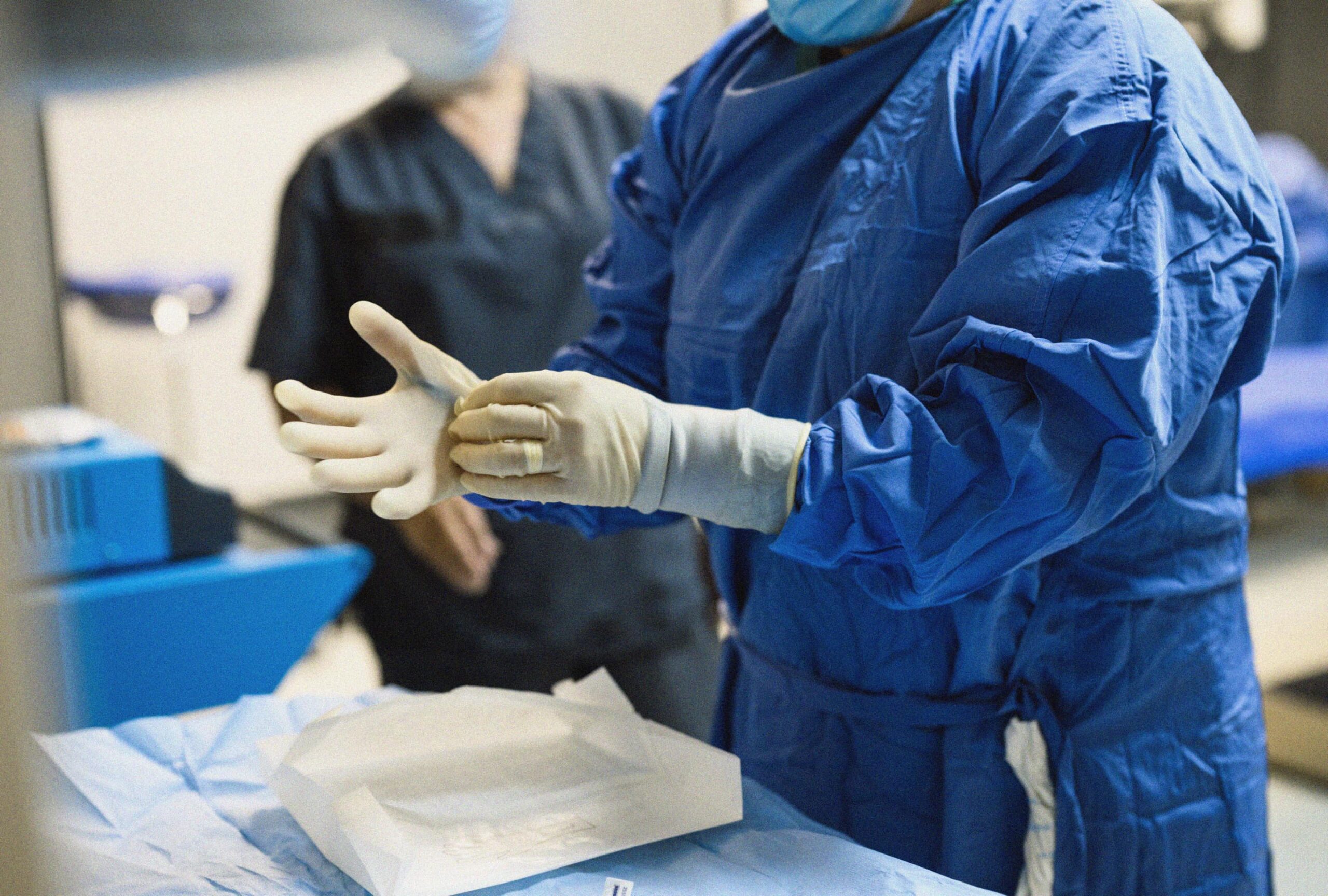 Doctor taking off plastic gloves